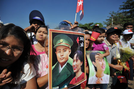 Supporters hold pictures of Aung San Suu Kyi and her father General Aung San